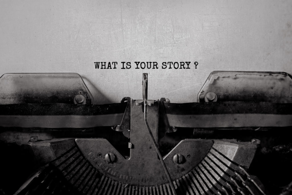 'What’s Your Story?’ typed on paper using a typewriter.