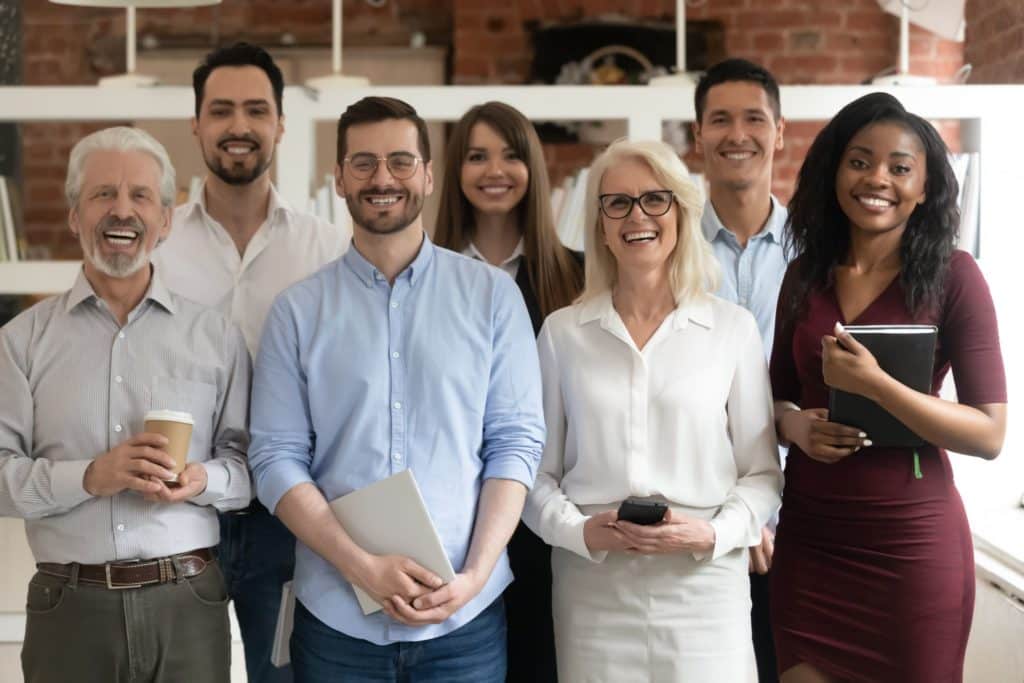 A group of professionals stand together, smiling at the camera.