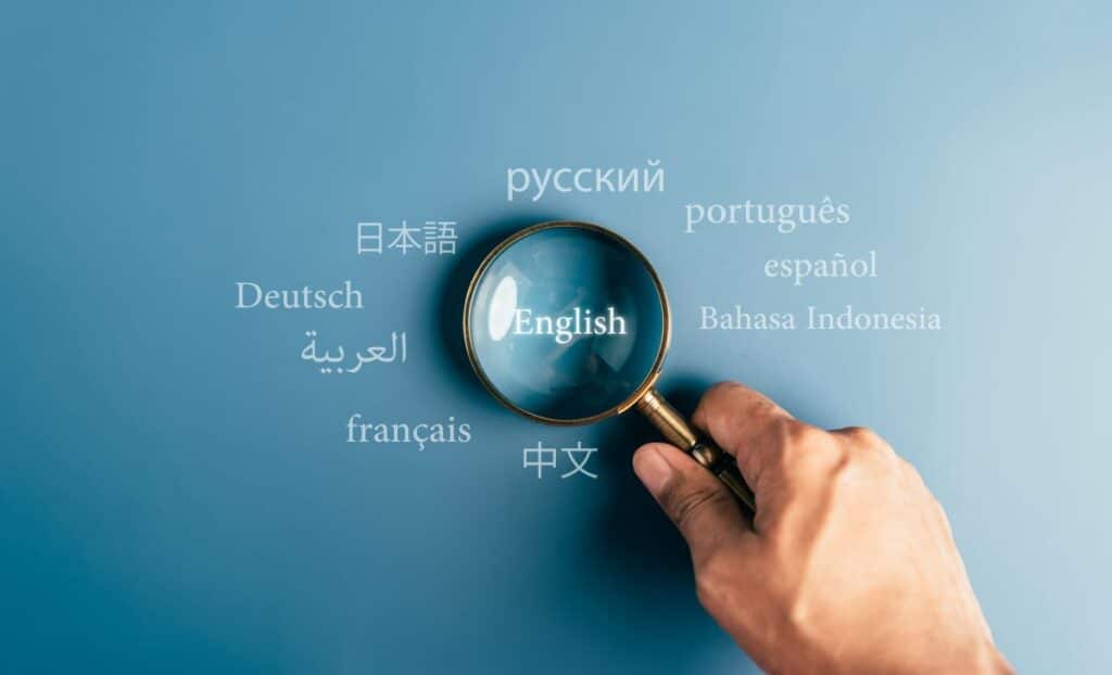 A magnifying glass is held over multiple language names, focusing on English.