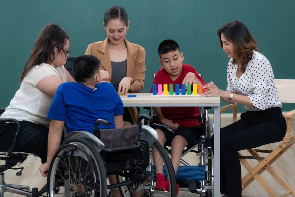 A teacher and her students with disabilities play a classroom game.