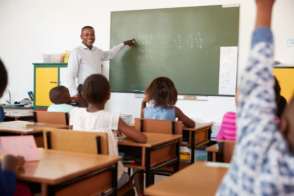 Teacher in front of classrom instructing students