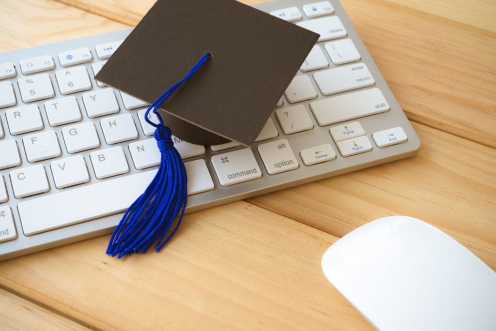 Graduation cap on keyboard with mouse.