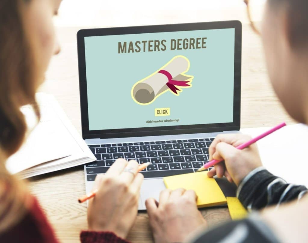 Two people look at a master’s degree program on a laptop.